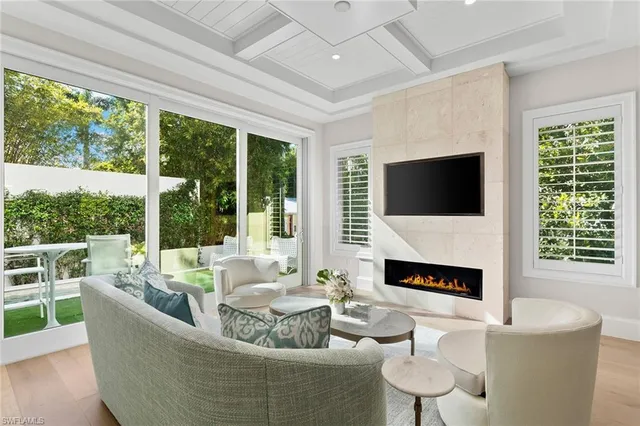 a living room with fireplace furniture and a large window