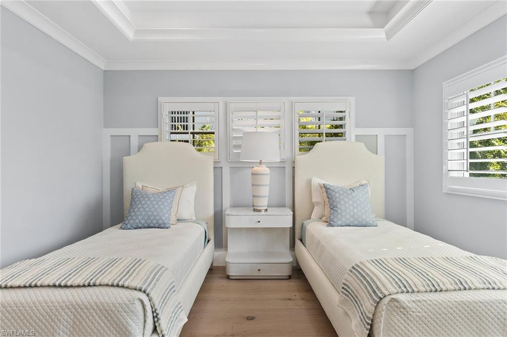 810 9th Street South Naples, FL 34102 - Photo 23 of 32 a bedroom with a white bed and wooden floor
