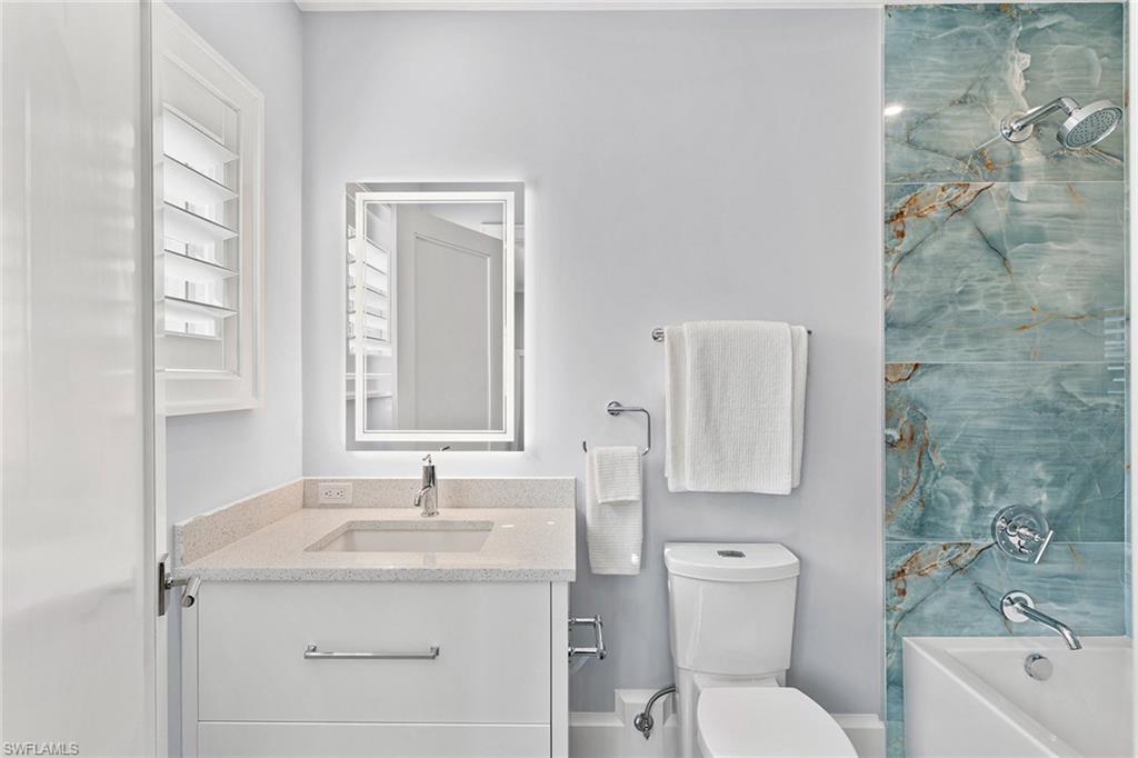 810 9th Street South Naples, FL 34102 - Photo 24 of 32 a bathroom with a granite countertop sink a toilet and a tub