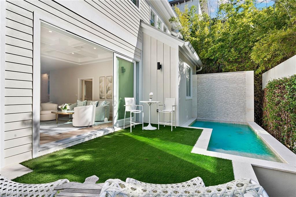 810 9th Street South Naples, FL 34102 - Photo 26 of 32 a view of a chair and table in backyard of the house