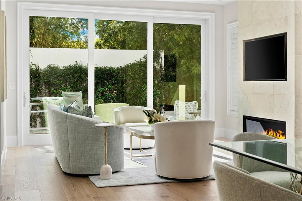 810 9th Street South Naples, FL 34102 - Photo 5 of 32 a living room with a large window and a fireplace