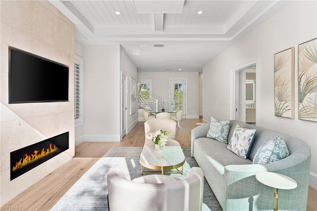 810 9th Street South Naples, FL 34102 - Photo 6 of 32 a living room with furniture a flat screen tv and a fireplace