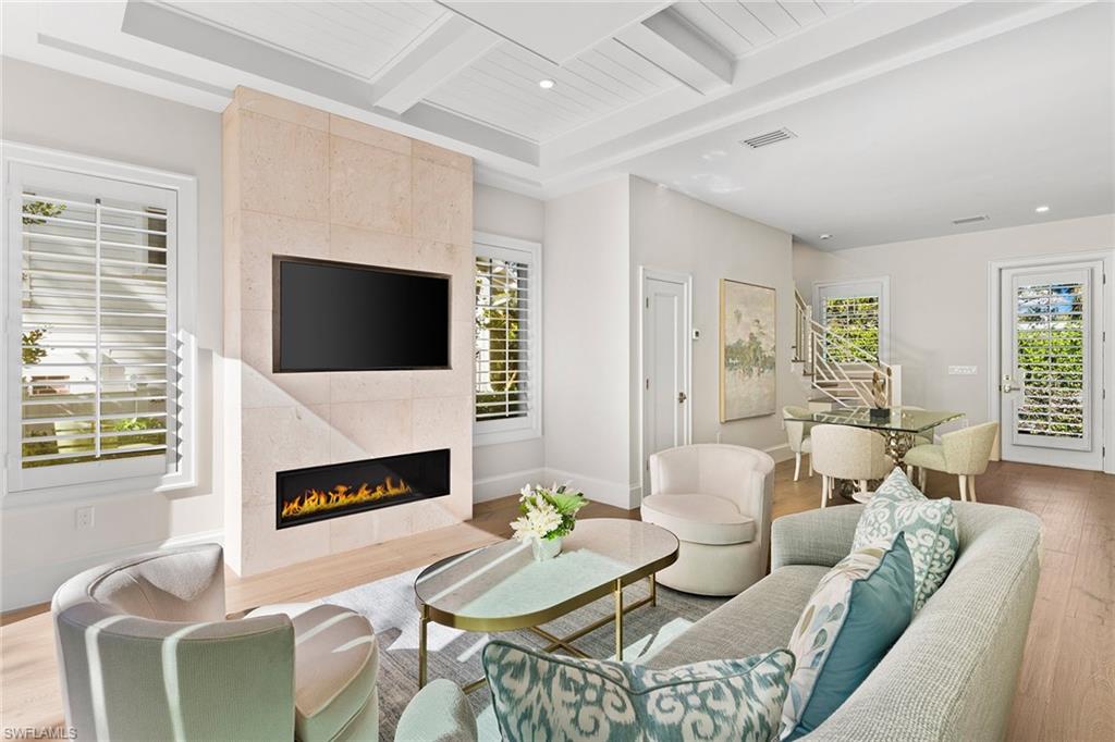 810 9th Street South Naples, FL 34102 - Photo 7 of 32 a living room with furniture a fireplace and a flat screen tv