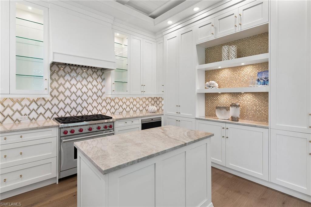 810 9th Street South Naples, FL 34102 - Photo 9 of 32 a kitchen with white cabinets and appliances
