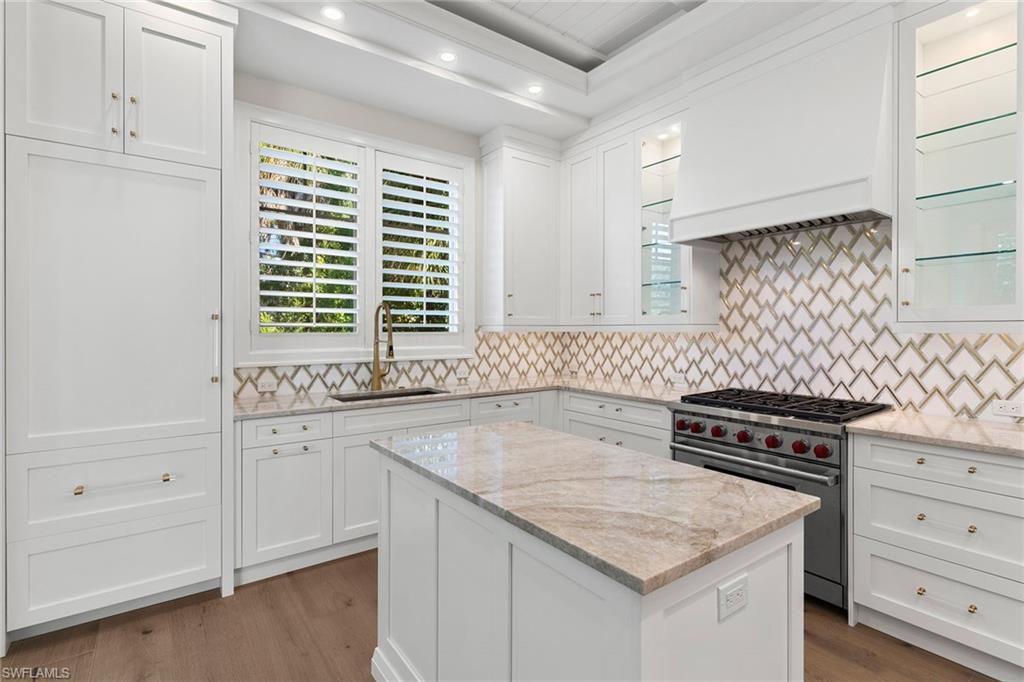 810 9th Street South Naples, FL 34102 - Photo 10 of 32 a kitchen with granite countertop a sink a stove and cabinets
