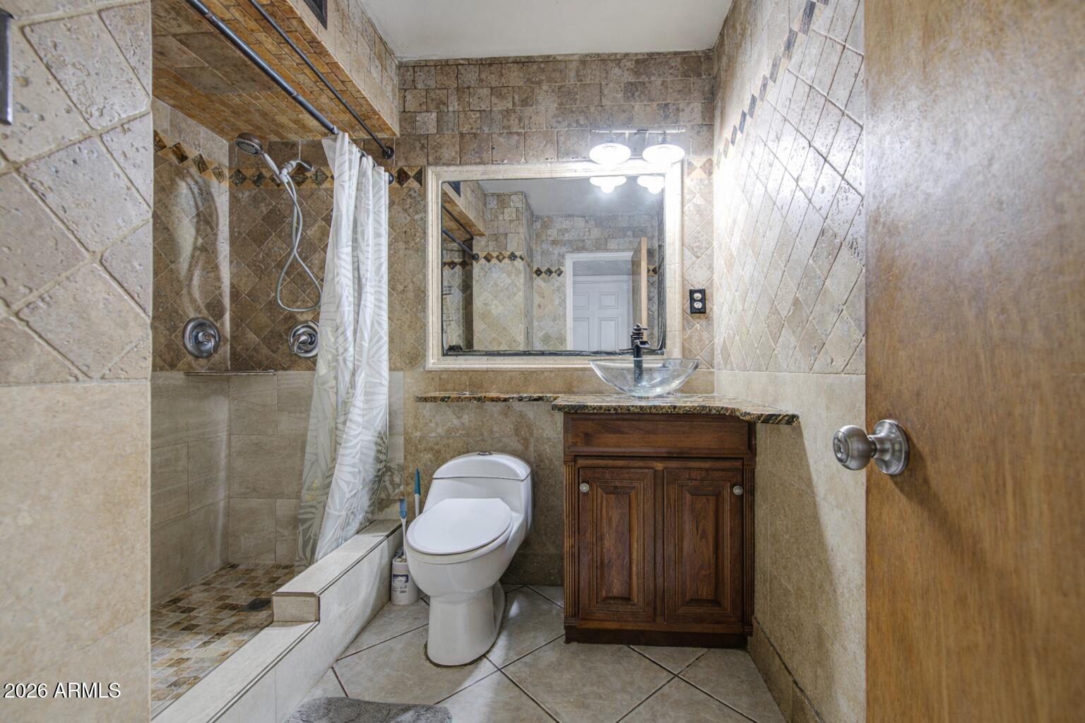 3107 West Montebello Avenue Phoenix, AZ 85017 - Photo 24 of 30 a bathroom with a granite countertop sink toilet and shower