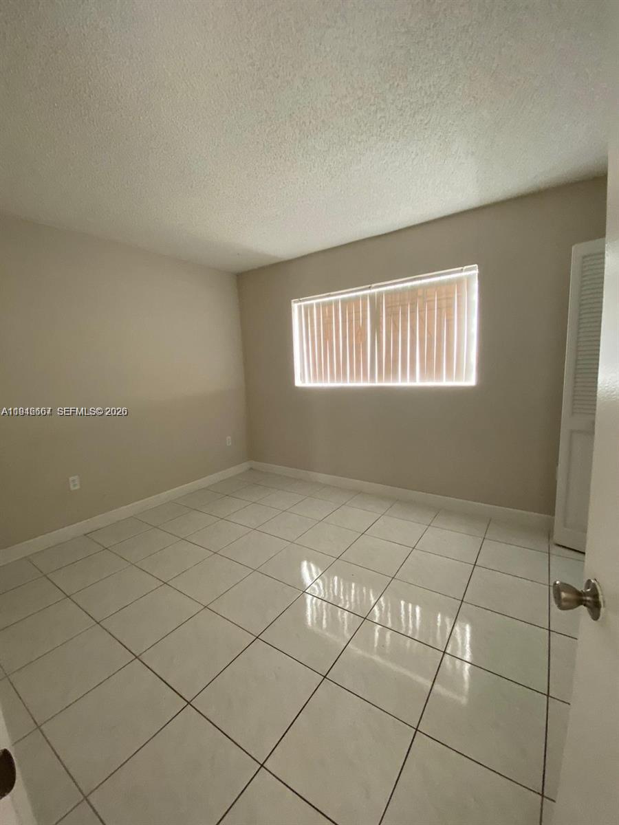 2441 Northwest 13th Street, Unit 71 Miami, FL 33125 - Photo 8 of 12 a view of an empty room with a window