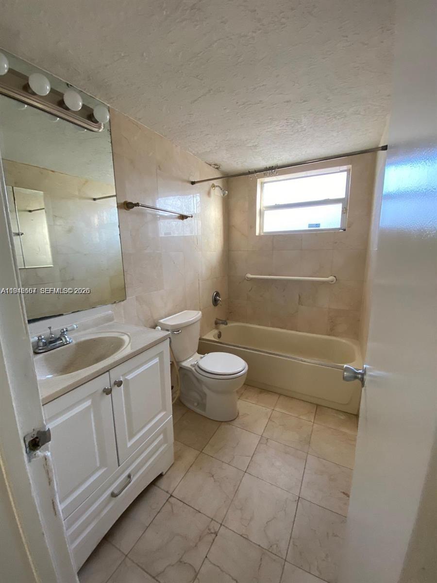 2441 Northwest 13th Street, Unit 71 Miami, FL 33125 - Photo 9 of 12 a bathroom with a toilet sink and mirror