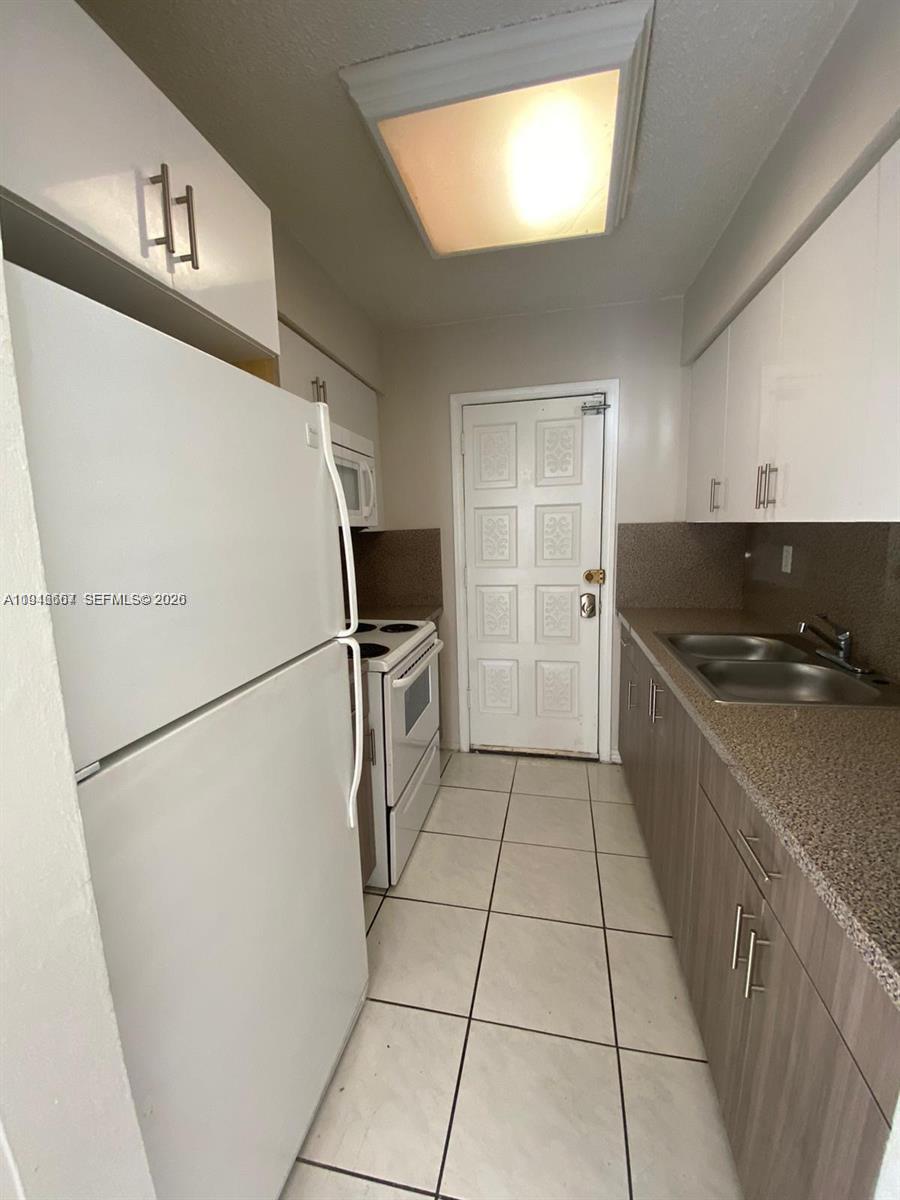 2441 Northwest 13th Street, Unit 71 Miami, FL 33125 - Photo 10 of 12 a kitchen with a refrigerator and a stove