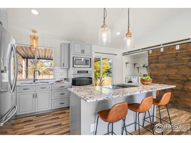 a kitchen with granite countertop a table chairs stove and cabinets