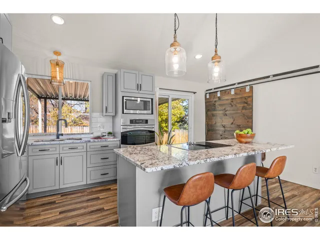 a kitchen with granite countertop a stove a sink cabinets and dining table