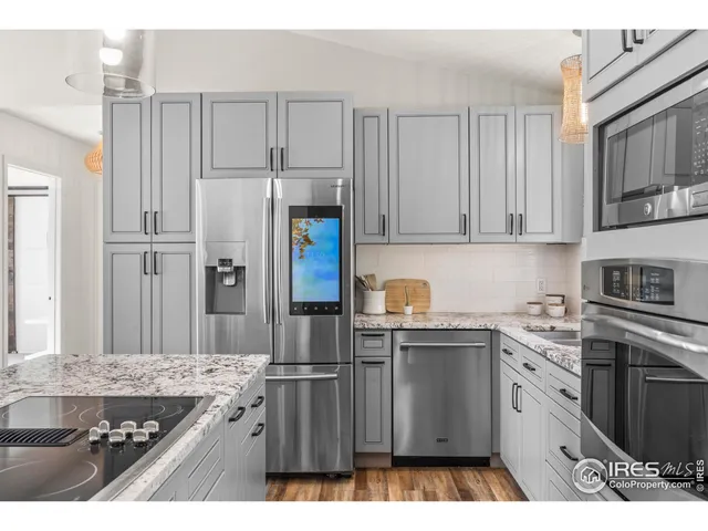 a kitchen with stainless steel appliances granite countertop a stove a refrigerator and a cabinets
