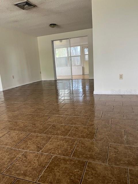 7034 Coral Reef Drive Port Richey, FL 34668 - Photo 3 of 9 an empty room with wooden floor and windows