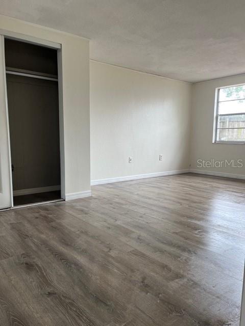 7034 Coral Reef Drive Port Richey, FL 34668 - Photo 8 of 9 an empty room with wooden floor closet and windows
