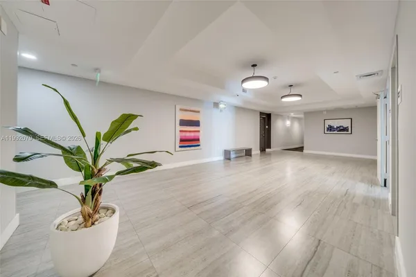 a view of a hallway with wooden floor and a potted plant
