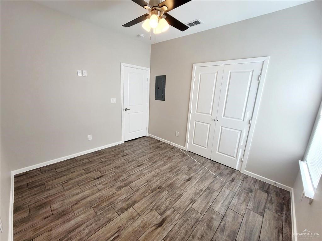 1312 Petri Drive, Unit 2 Weslaco, TX 78596 - Photo 8 of 15 wooden floor in an empty room with a window
