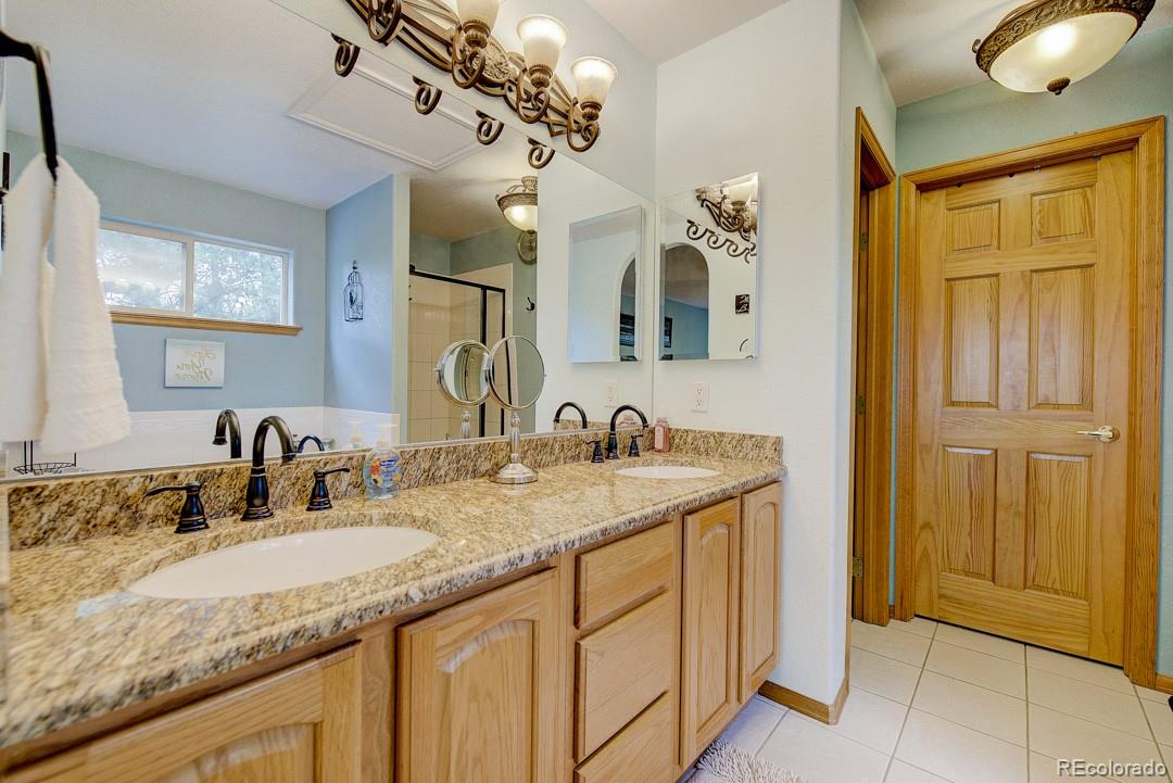 25 Buggy Whip Road Bailey, CO 80421 - Photo 26 of 40 a bathroom with a granite countertop sink and a mirror
