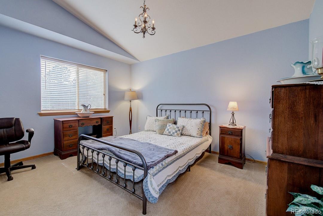 25 Buggy Whip Road Bailey, CO 80421 - Photo 28 of 40 a bedroom with a bed and a chandelier