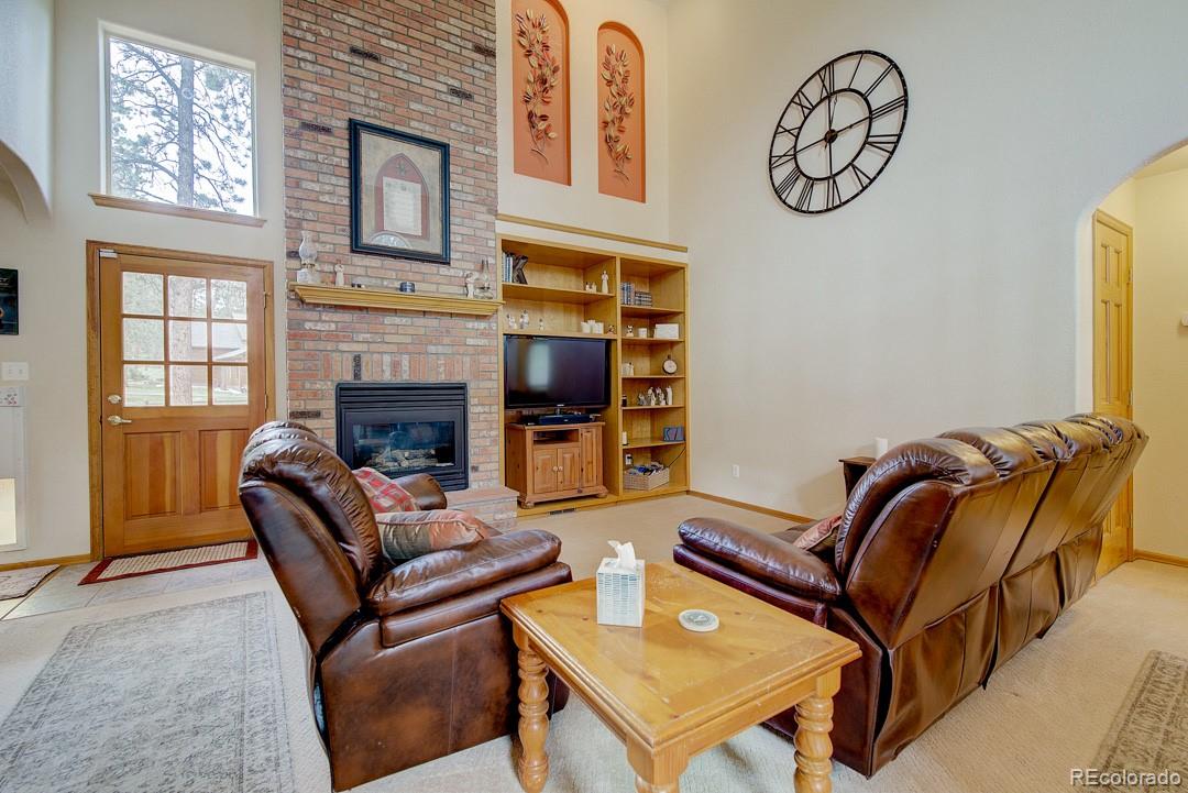 25 Buggy Whip Road Bailey, CO 80421 - Photo 4 of 40 a living room with furniture a flat screen tv and a fireplace