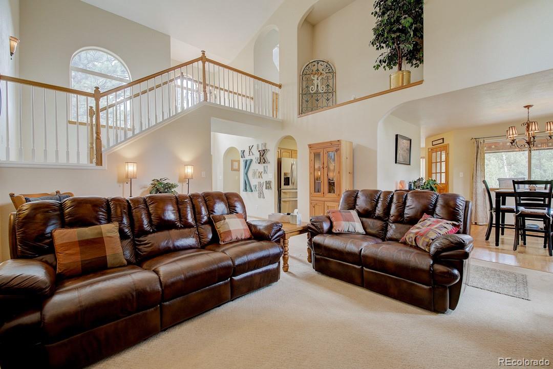 25 Buggy Whip Road Bailey, CO 80421 - Photo 6 of 40 a living room with furniture and a chandelier