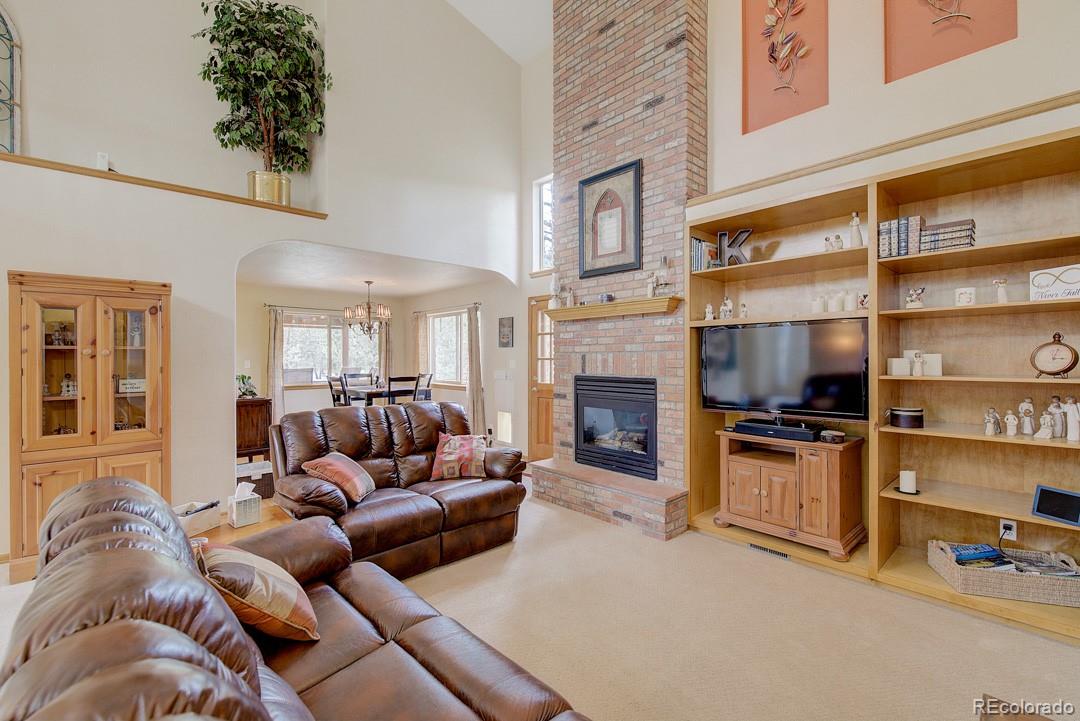 25 Buggy Whip Road Bailey, CO 80421 - Photo 7 of 40 a living room with furniture a fireplace and a flat screen tv
