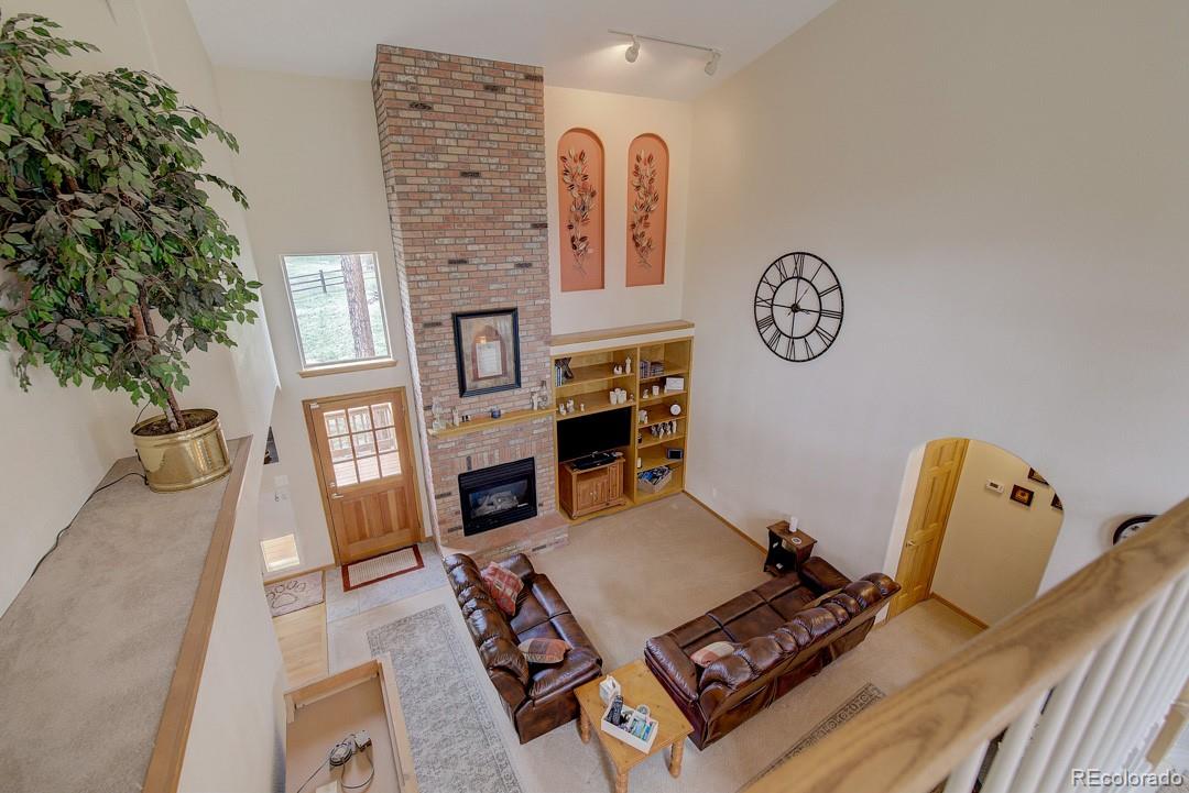 25 Buggy Whip Road Bailey, CO 80421 - Photo 8 of 40 a living room with furniture and a fireplace