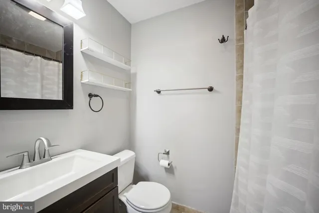 a bathroom with a toilet a sink and mirror