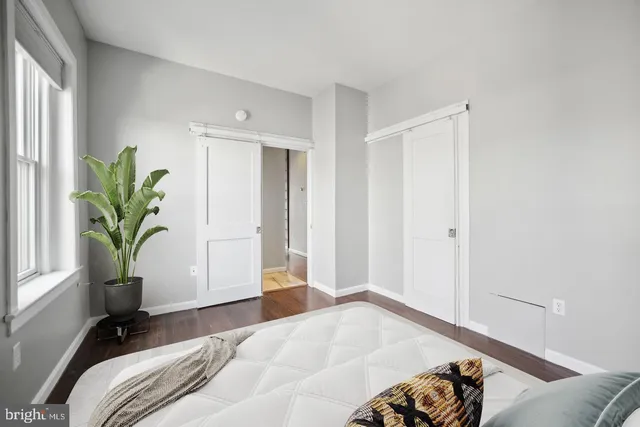 a bedroom with a bed and a potted plant