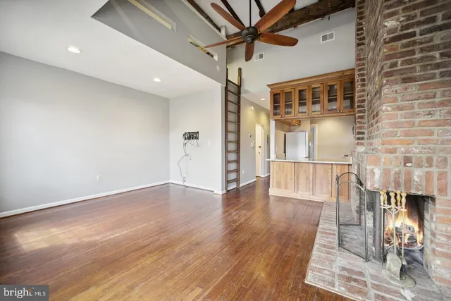 a view of a livingroom with wooden floor and a ceiling fan