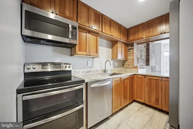 a kitchen with stainless steel appliances granite countertop a stove microwave and sink