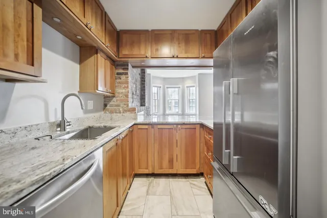 a bathroom with a granite countertop sink a mirror and shower