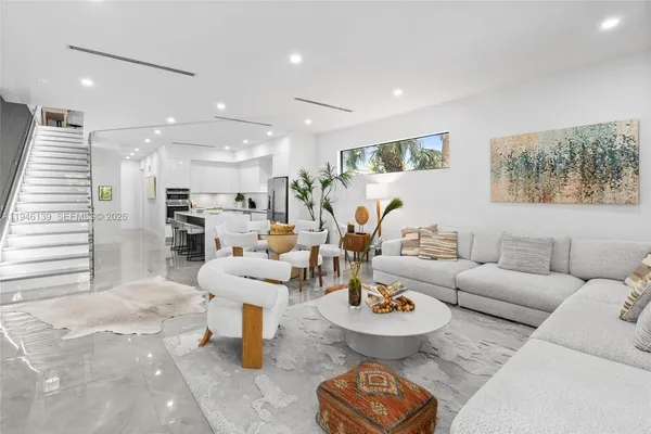 a room with stainless steel appliances kitchen island granite countertop furniture and a view of living room