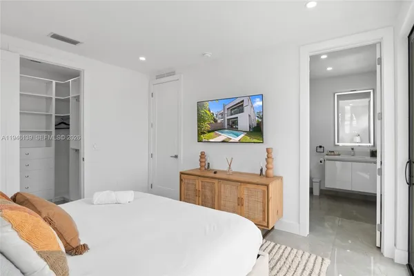 a bedroom with a bed and a flat screen tv
