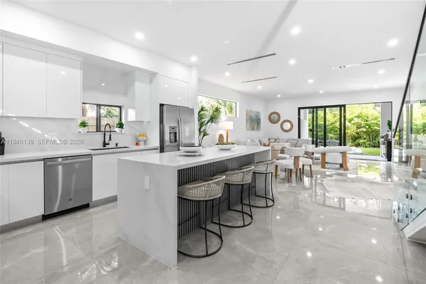 a kitchen with a table chairs sink and cabinets