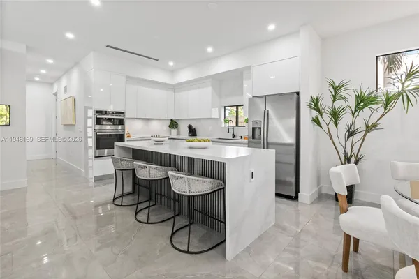 a kitchen with stainless steel appliances a refrigerator sink and white cabinets
