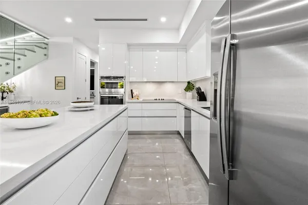 a living room with lots of white furniture and a large window
