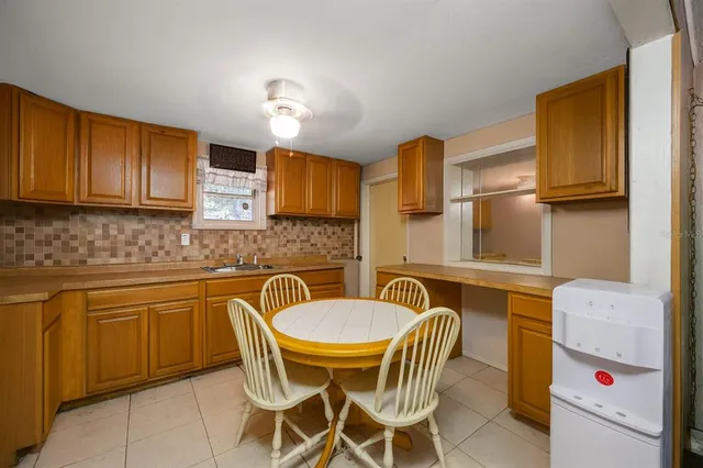 a kitchen with a table chairs sink and cabinets