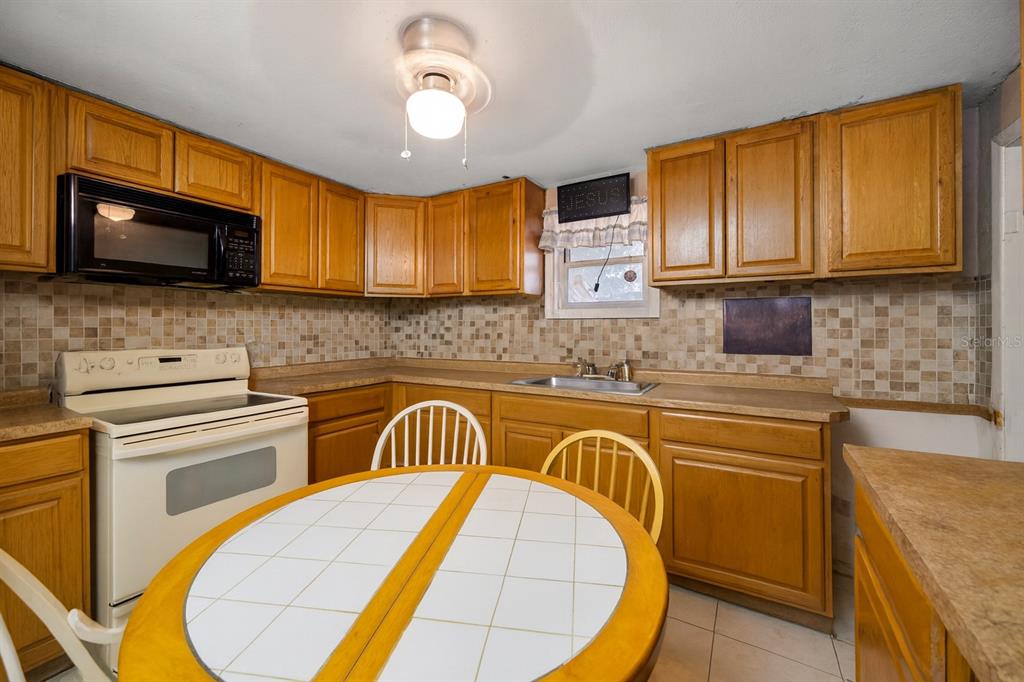 1324 Milton Street Clearwater, FL 33756 - Photo 14 of 47 a kitchen with stainless steel appliances granite countertop a sink stove and microwave