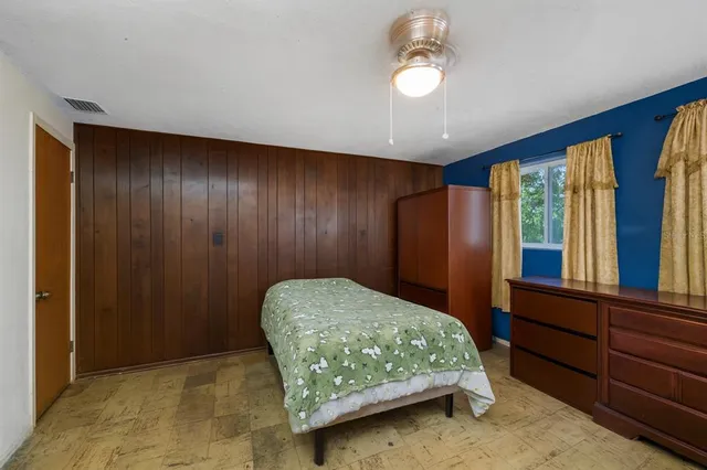 a bedroom with a bed window and a dresser