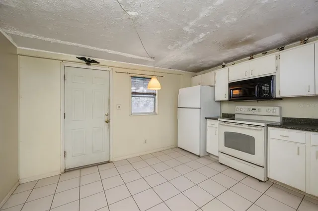 a kitchen with white cabinets stainless steel appliances and a window