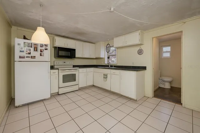 a kitchen with a sink a stove top oven and cabinets