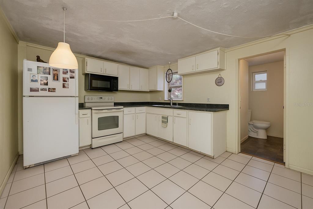 1324 Milton Street Clearwater, FL 33756 - Photo 28 of 47 a kitchen with a sink a stove top oven and cabinets