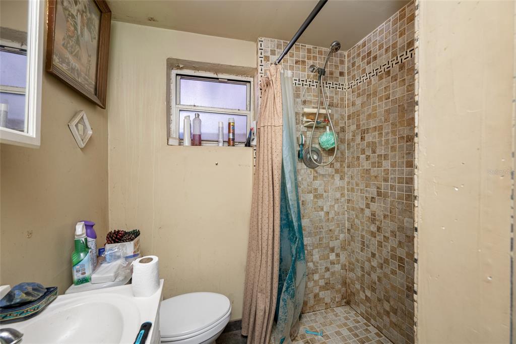 1324 Milton Street Clearwater, FL 33756 - Photo 34 of 47 a bathroom with a shower a toilet and a sink