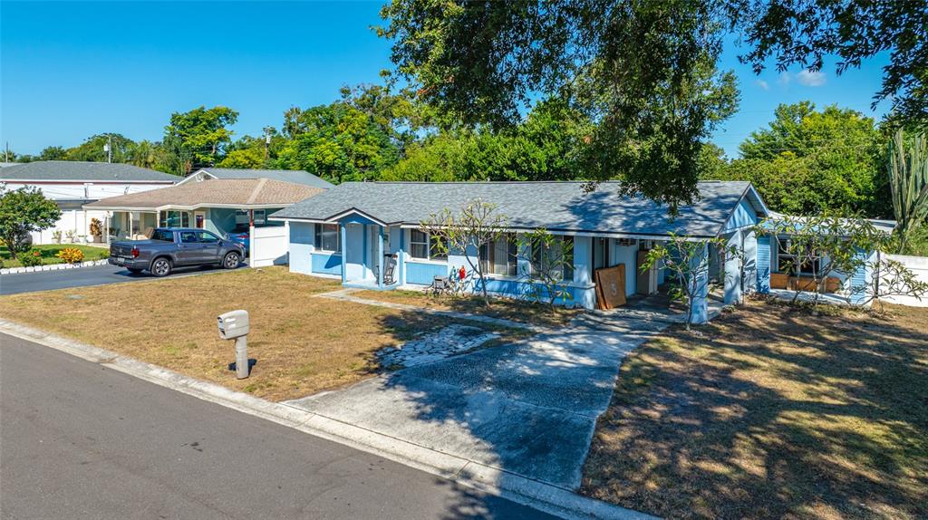 1324 Milton Street Clearwater, FL 33756 - Photo 45 of 47 a view of a white house with a yard plants and large tree