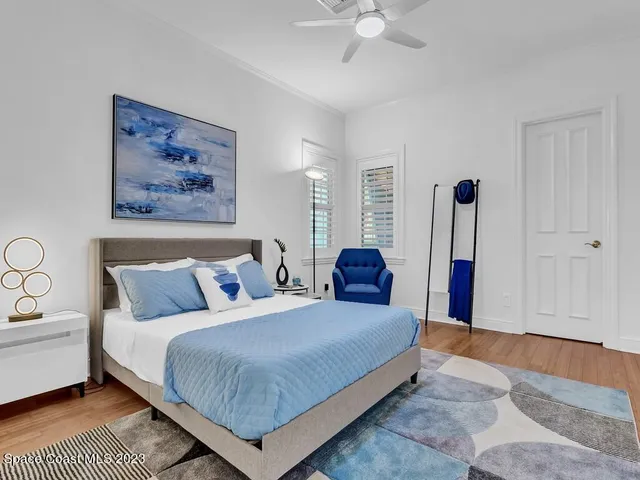 a spacious bedroom with a bed and a chandelier