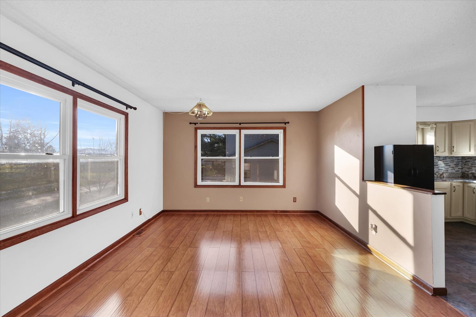 104 Grant Street Philo, IL 61864 - Photo 7 of 44 a view of an empty room with a window and wooden floor