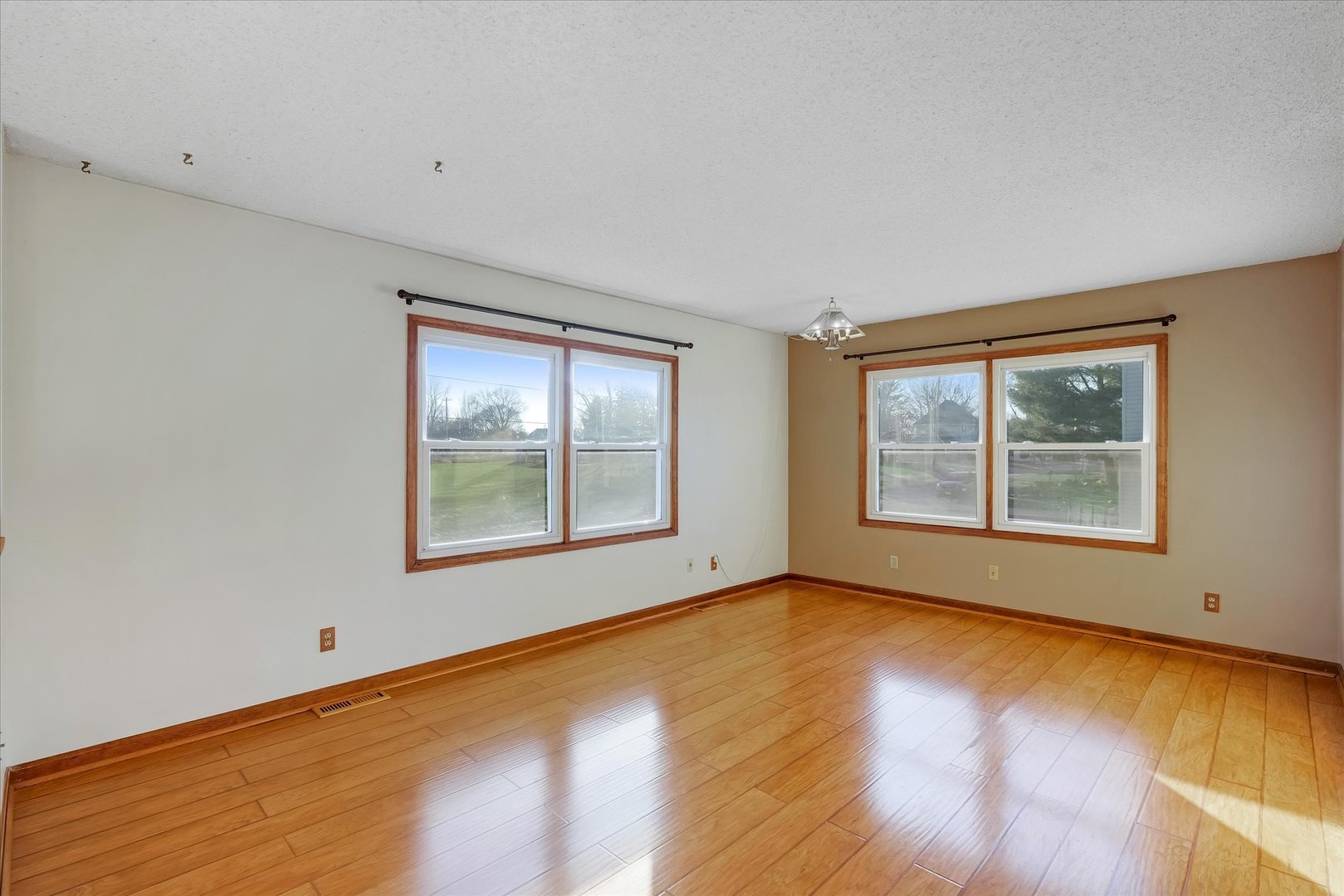 104 Grant Street Philo, IL 61864 - Photo 8 of 44 a view of an empty room with a window and wooden floor