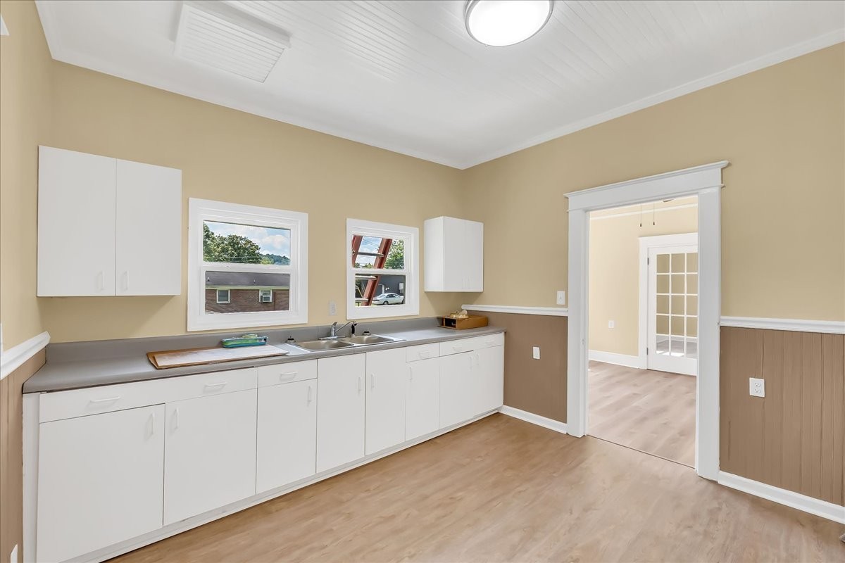 104 Locust Street Liberty, TN 37095 - Photo 16 of 57 a large white kitchen with a sink and dishwasher with wooden floor