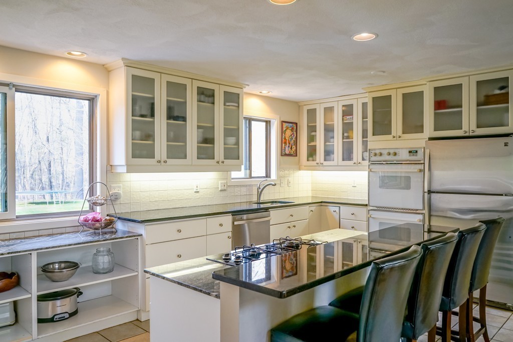 33 Sunset Road Carlisle, MA 01741 - Photo 5 of 27 a kitchen with kitchen island granite countertop a stove and a sink