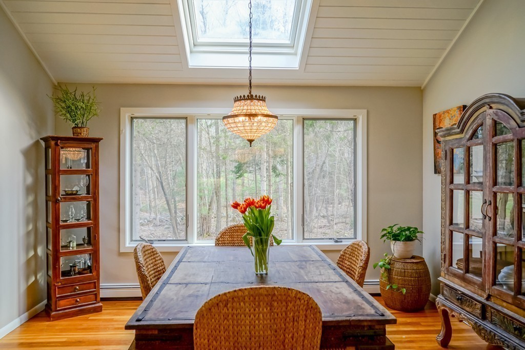 33 Sunset Road Carlisle, MA 01741 - Photo 7 of 27 a dining room with furniture a potted plant and wooden floor